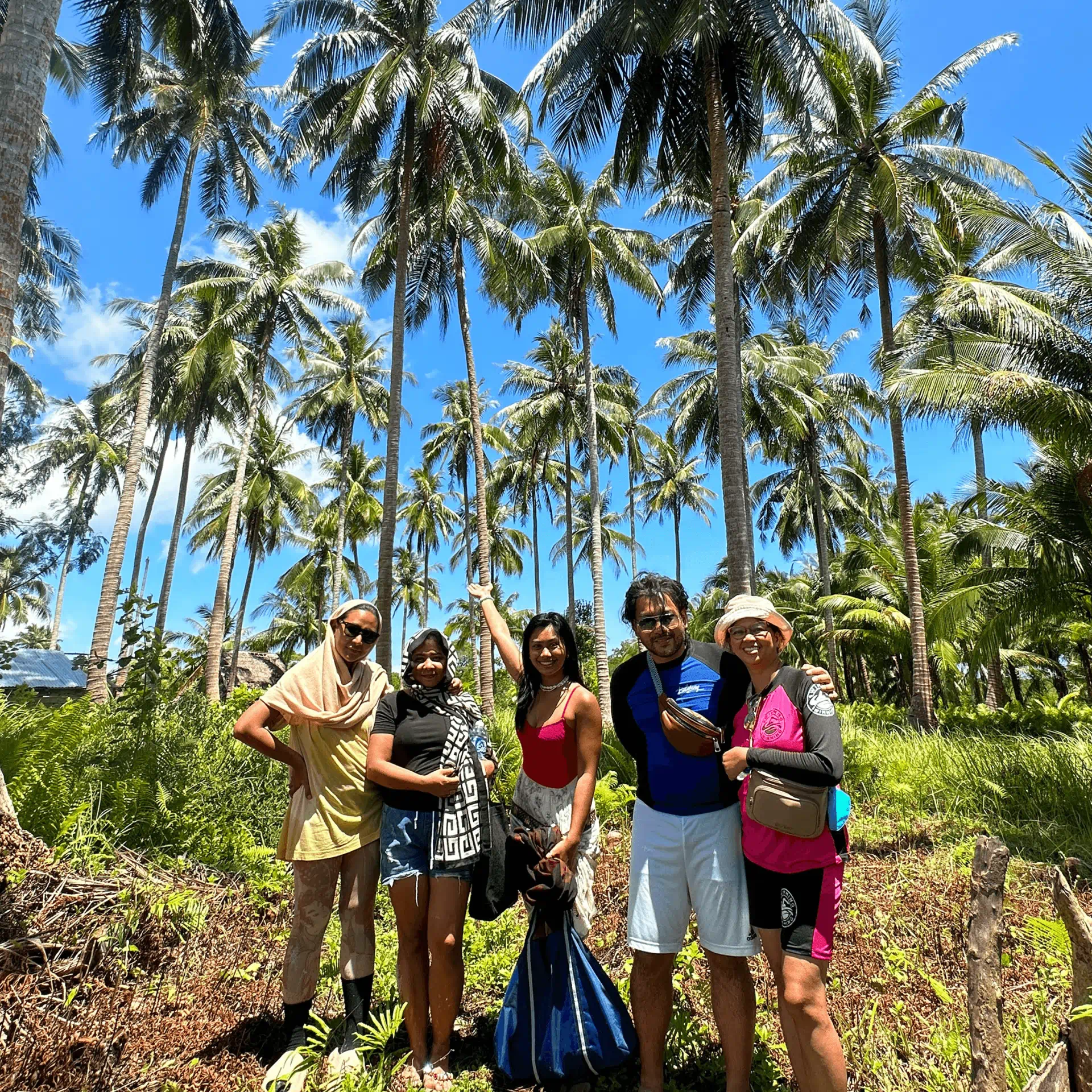 Seanderg team and clients pose under a grove of coconut trees at Silom Beachfront.